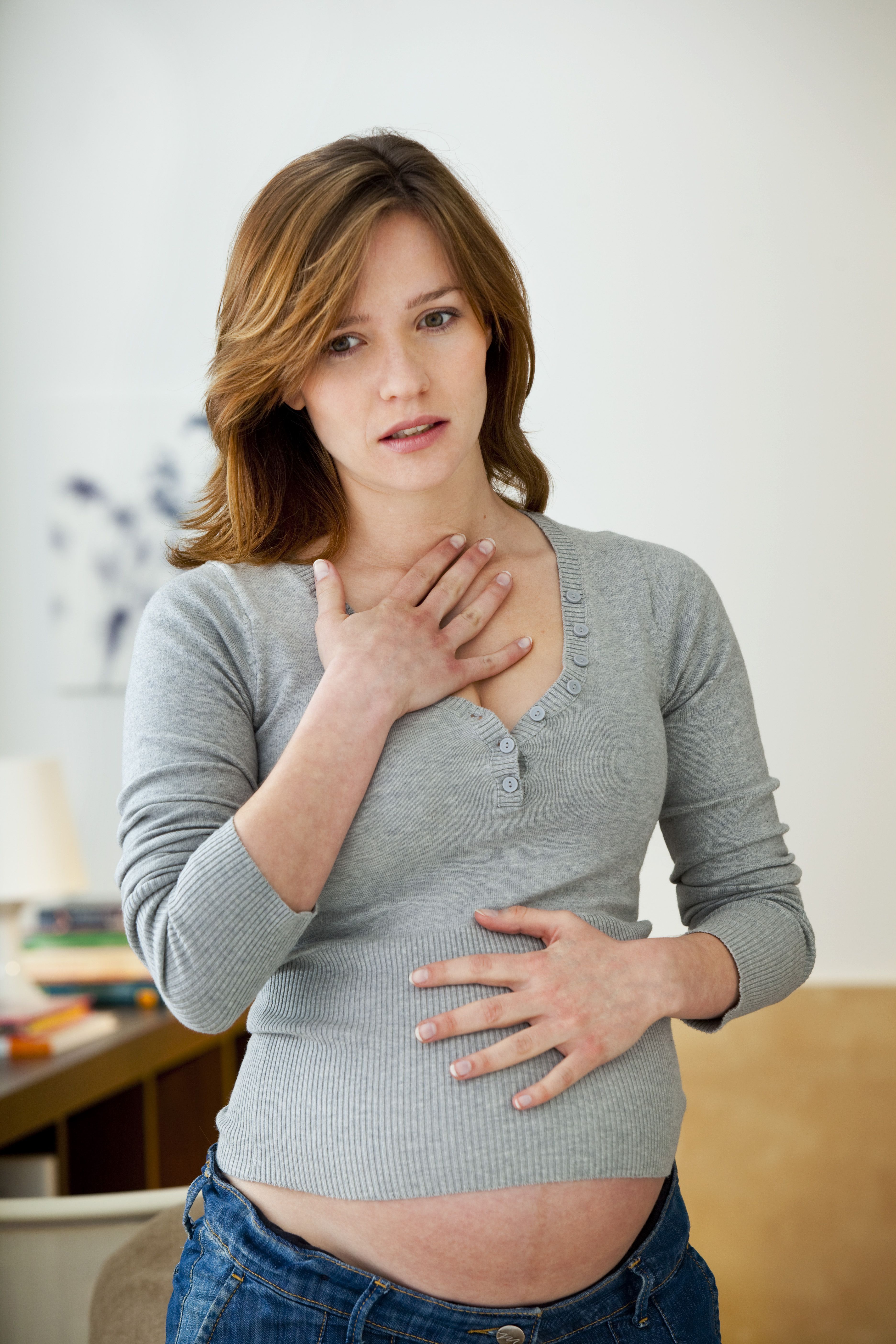Pregnant woman feeling her chest and stomach